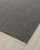 Gray rug with a textured surface on a light wood floor