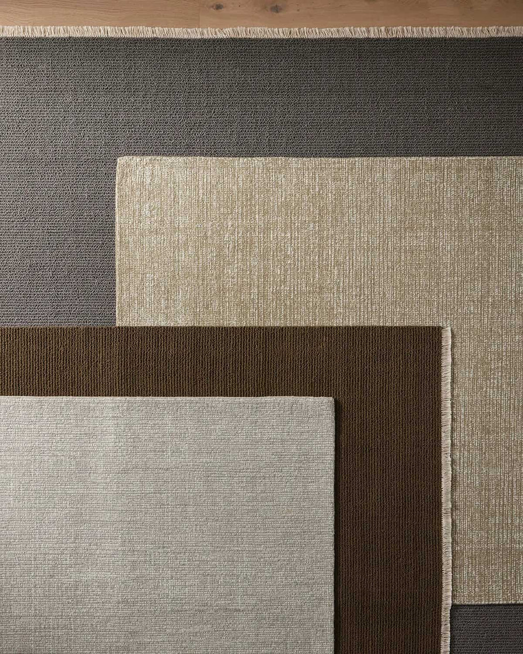 Close-up of various textured rugs in cool tones.