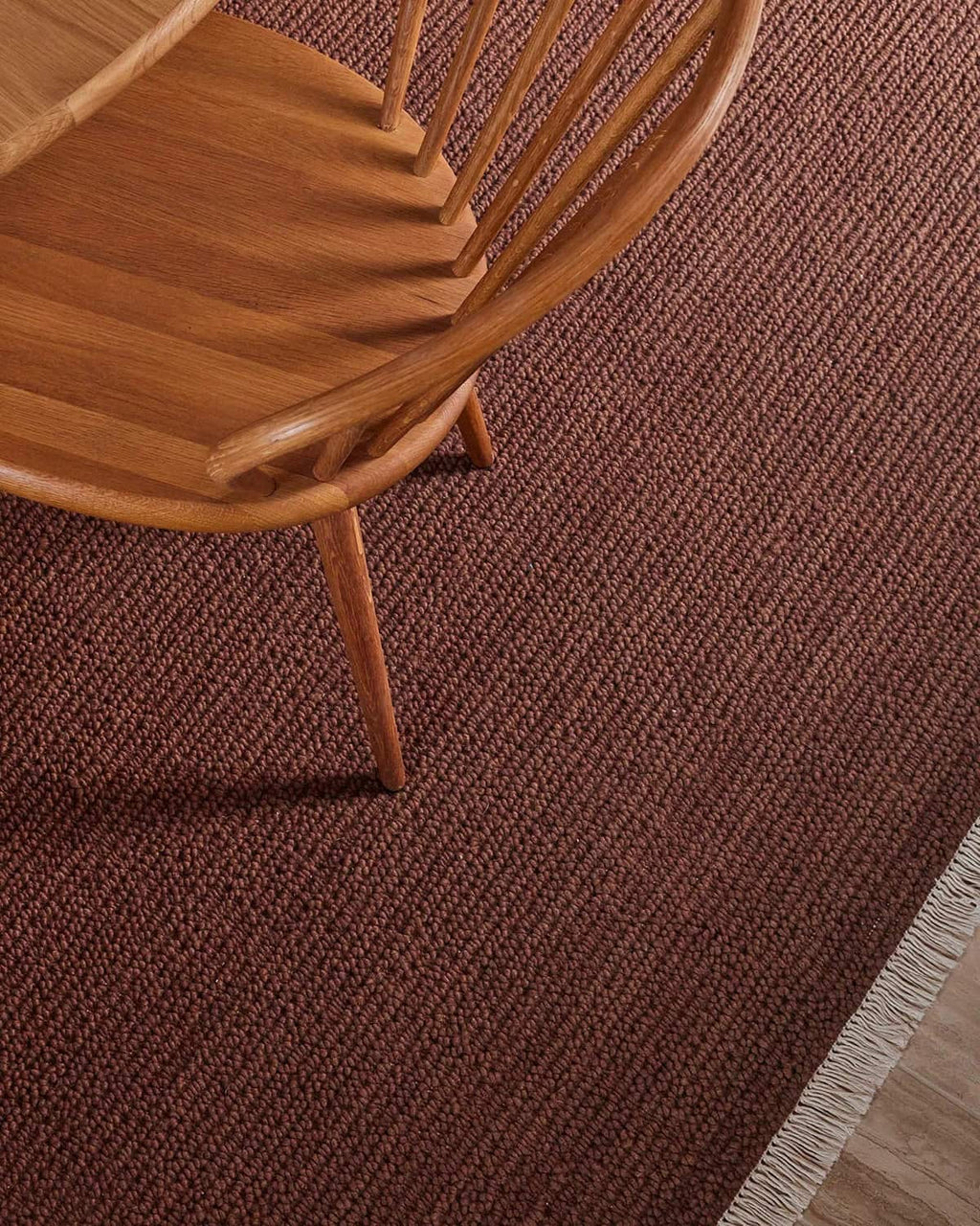 Wooden chair on a warm red-brown textured rug