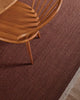 Wooden chair on a warm red-brown textured rug