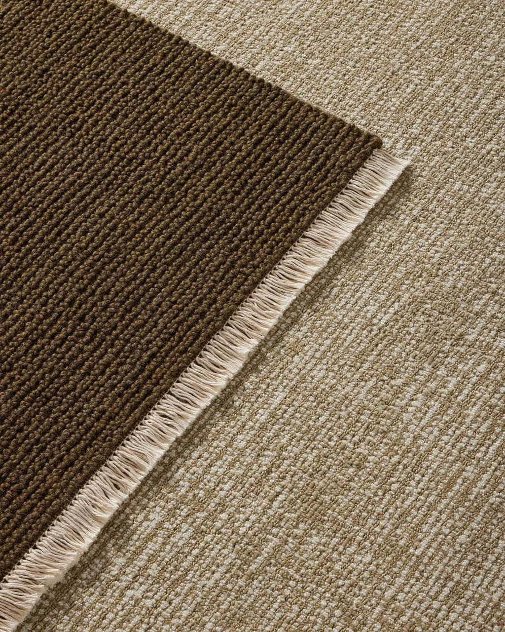 Close-up of green and beige textured floor rugs.