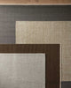 Close-up of various textured rugs in neutral colors.