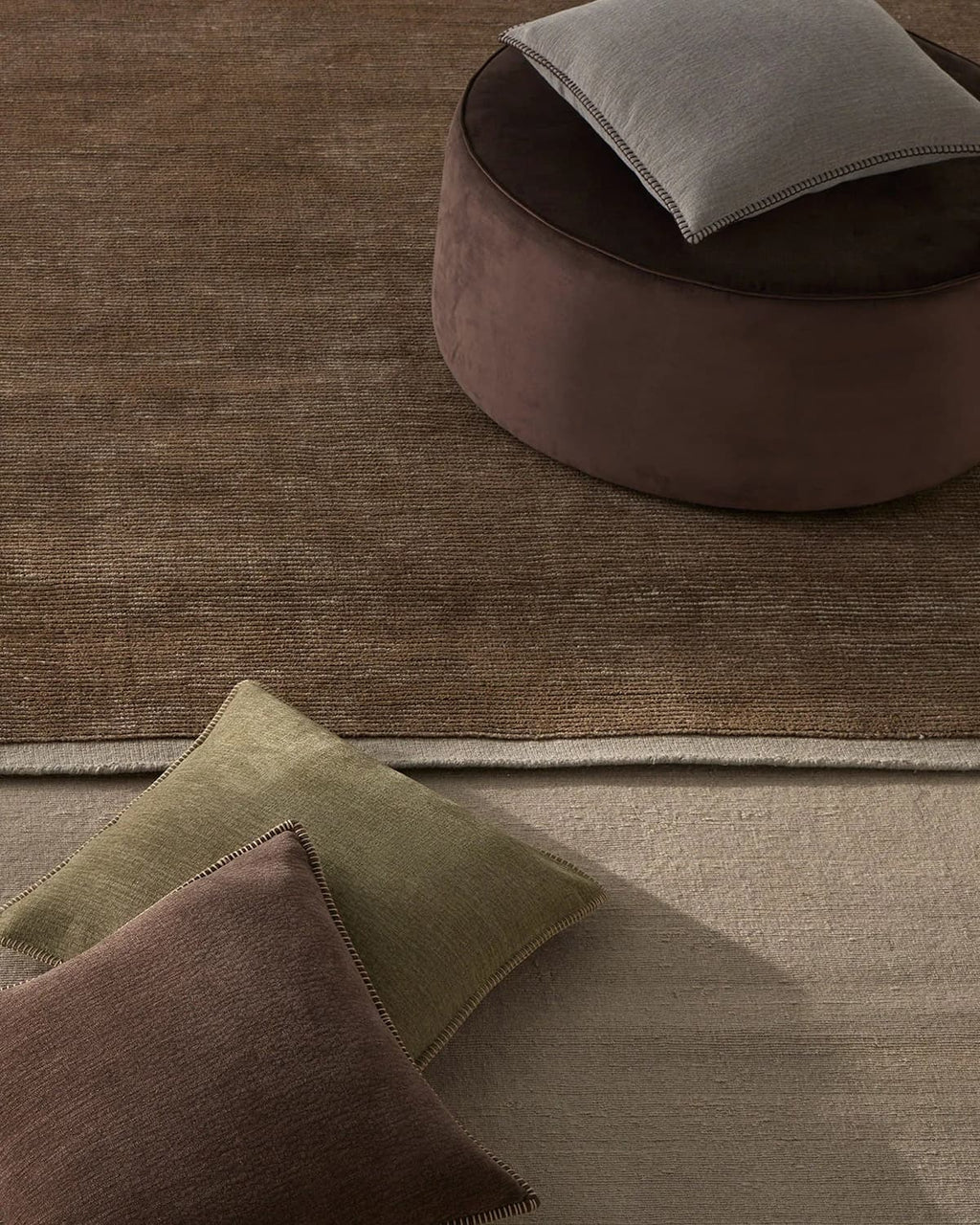 Weave Home NZ wool brown Textured rug with a round ottoman 