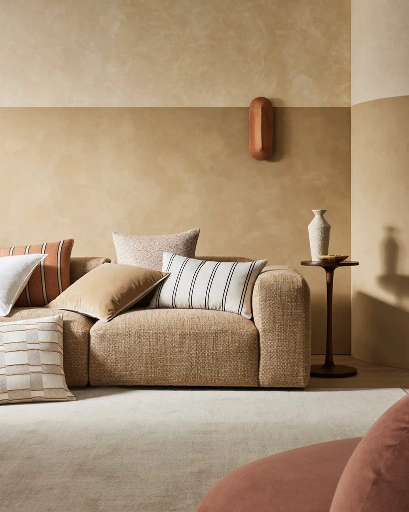 A modern living room in warm brown on-trend tones, featuring cushions by Weave Home nz