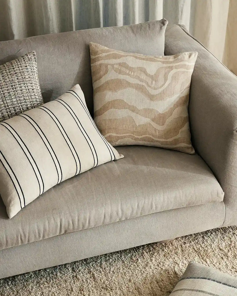 The Weave Home Vinnie lumbar striped cushion seen next to other neutral modern cushions