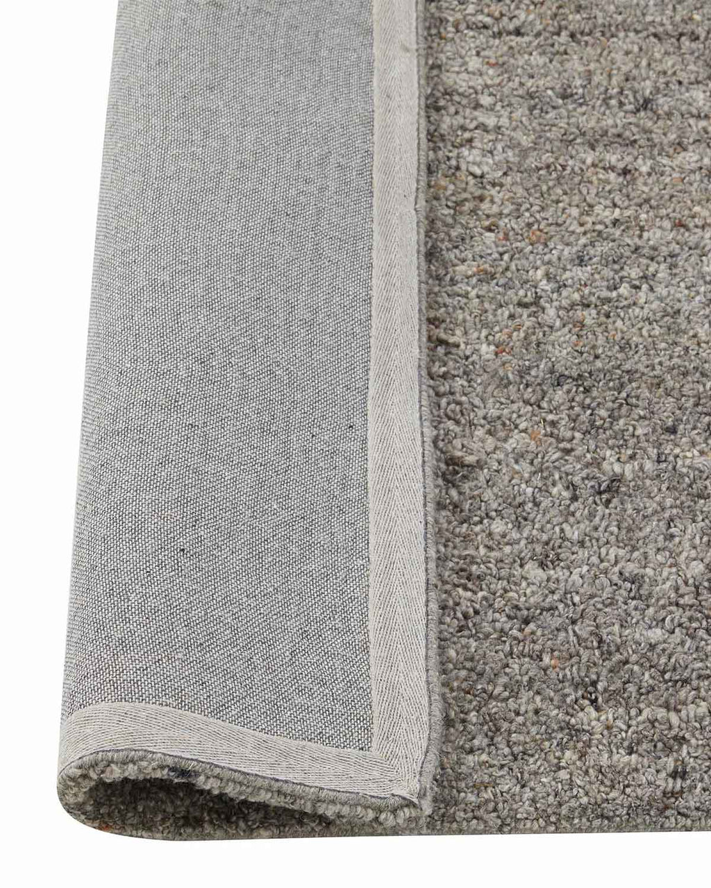 A close up view of a textural grey floor rug with loop piling, the underside is flipped up to show the durable cotton backing. 