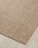 A corner image of a warm beige loop pile textural wool blend floor rug. 