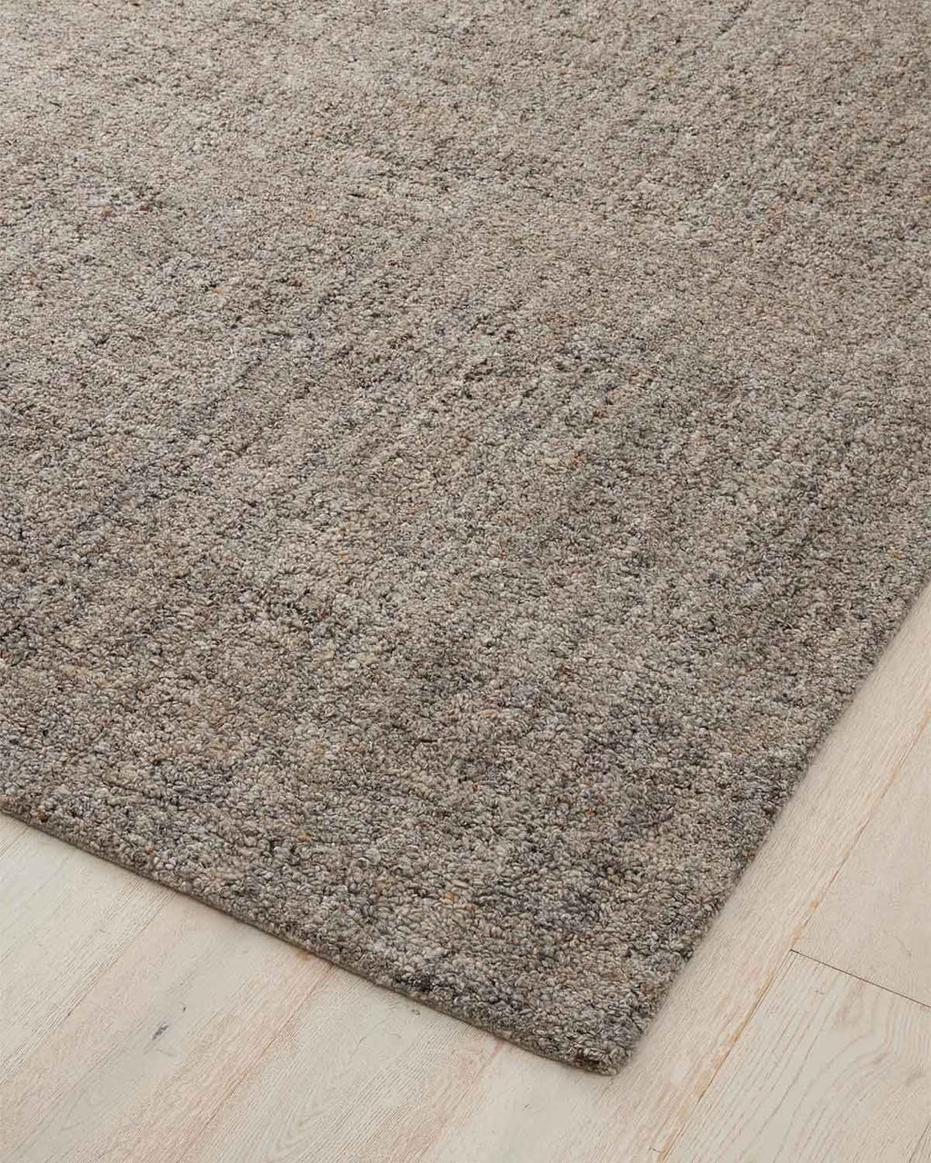 A warm grey toned floor rug with loop piling. 