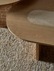 A textural woolen rug, in shades of honey brown and light beige, with subtle colour shifts by Soren Liv NZ and Globe West, situated under a designer coffee table