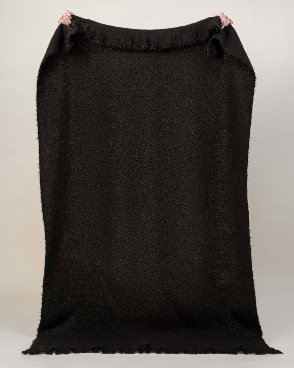 A full image of the Hyde throw blanket in Cocoa, a deep rich brown shade, generously sized with fringe edging. 