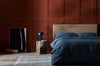 A textural woolen rug, in shades of honey brown and light beige, with subtle colour shifts by Soren Liv NZ and Globe West, in a chic modern bedroom. 