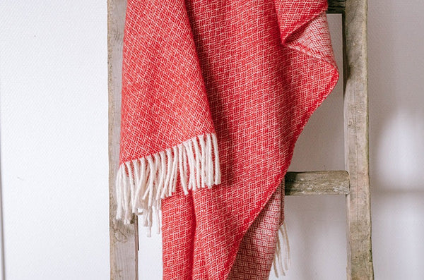 100% wool NZ throw blanket by Ruanui Station, in vibrant 'Rakaia red', shown draped