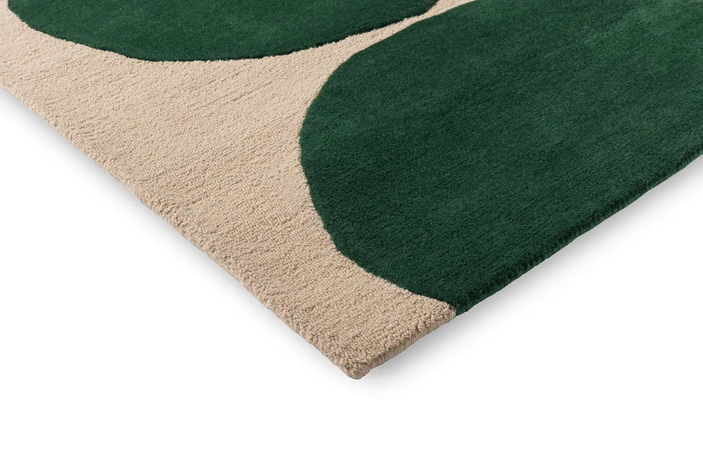 Close up corner view of the The Marimekko Isot Kivet rug in a rich green and calming cream showing the cut and loop pile