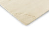 Close up corner view of the The Marimekko Isot Kivet wool floor rug in a calming natural white colour