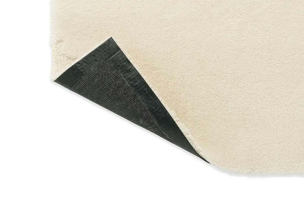 Corner folded to reveal underneath of the Marimekko Iso Unikko wool rug in natural white