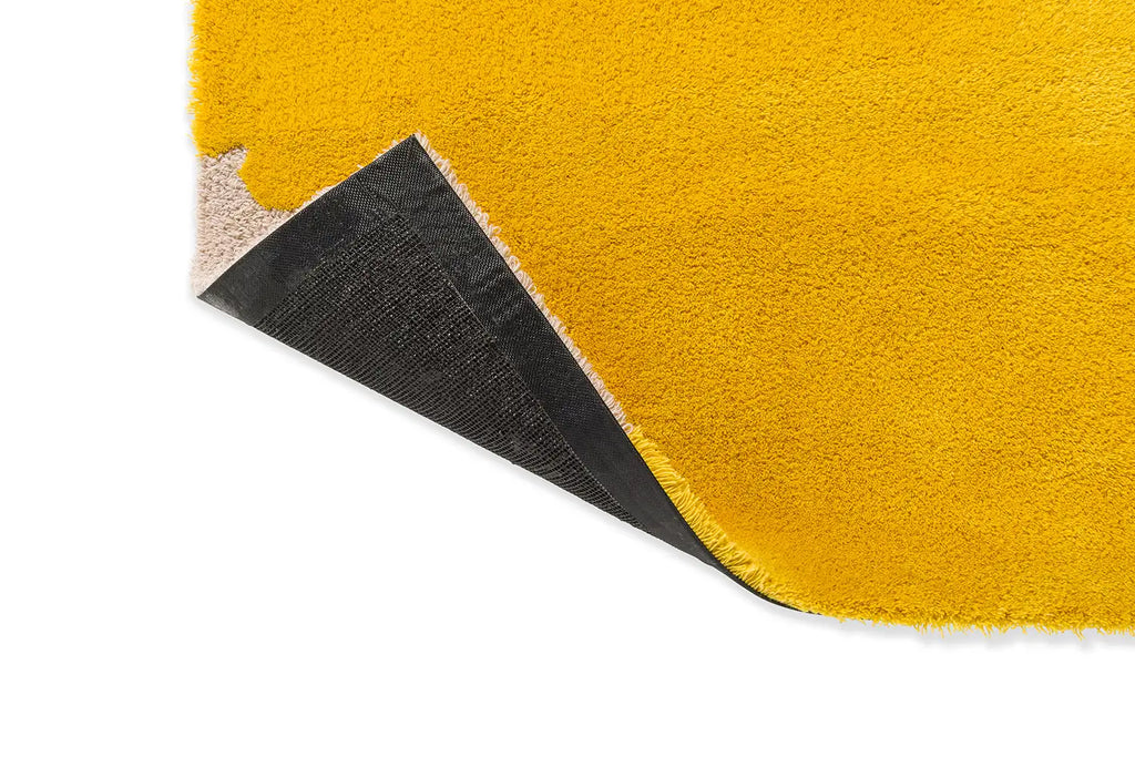 Corner close up of the Marimekko Iso Unikko wool rug in yellow with corner folded to reveal underneath