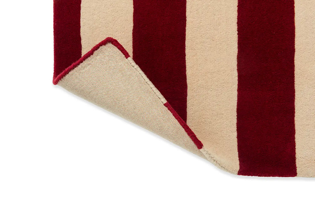 Close up view of the The Marimekko Ralli wool floor rug with corner folded up to reveal underneath