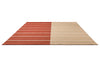 Perspective view of the Marimekko Tiibet floor rug, made from recycled PET yarns, in burnt orange colour