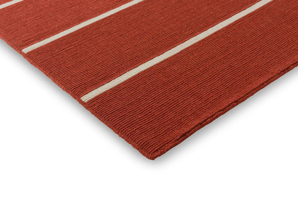 Close up corner shot of the Marimekko Tiibet floor rug, made from recycled PET yarns, in burnt orange colour