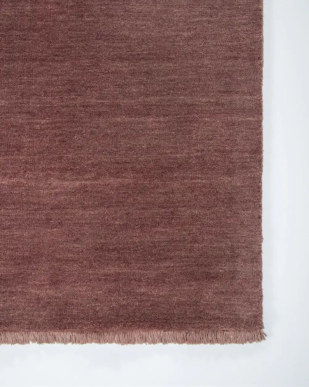 The Baya Sandringham cut pile wool floor rug with tasseled edge, in colour 'Merlot' red