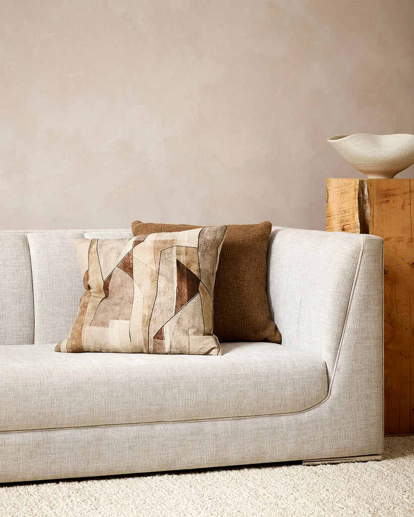 Brown patterned cushion featuring an abstract print design on 100% linen, on a couch with a solid brown cushion in a stylish home