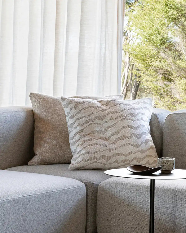 Baya white and beige patterned cushion on a couch in a contemporary living room
