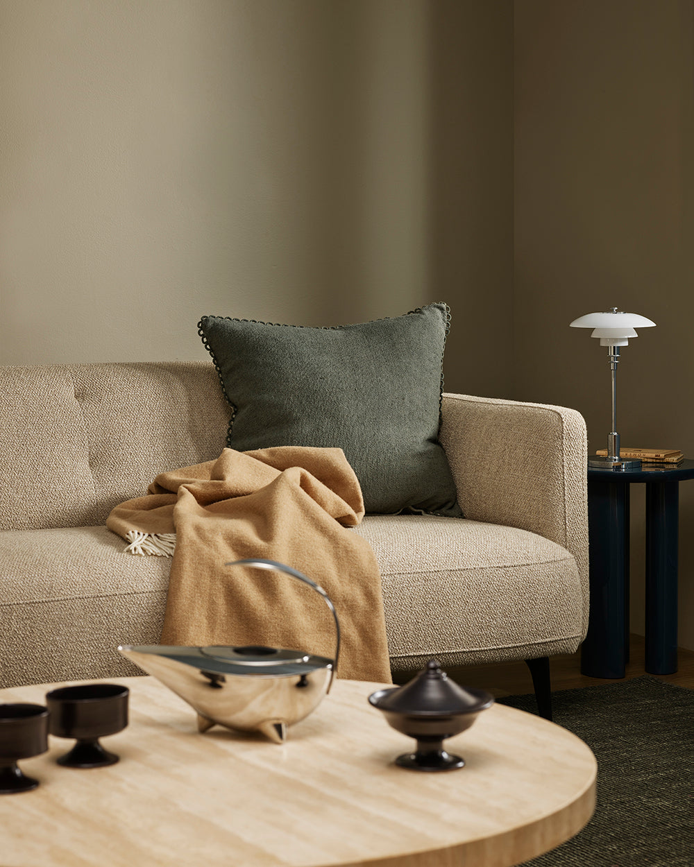 Baya Alden linen cotton blend cushion in Sage, styled on a sofa with a tan throw