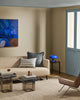 Baya Calden cotton lumbar cushion in Cloudburst, styled on a sofa near a blue-framed door