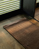 Baya Carla NZ wool floor mat in Cocoa, styled at an entrance beside a window in afternoon light.