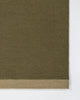 Baya Carla NZ wool floor mat in Military, close view of the woven texture and the pale sand end band.