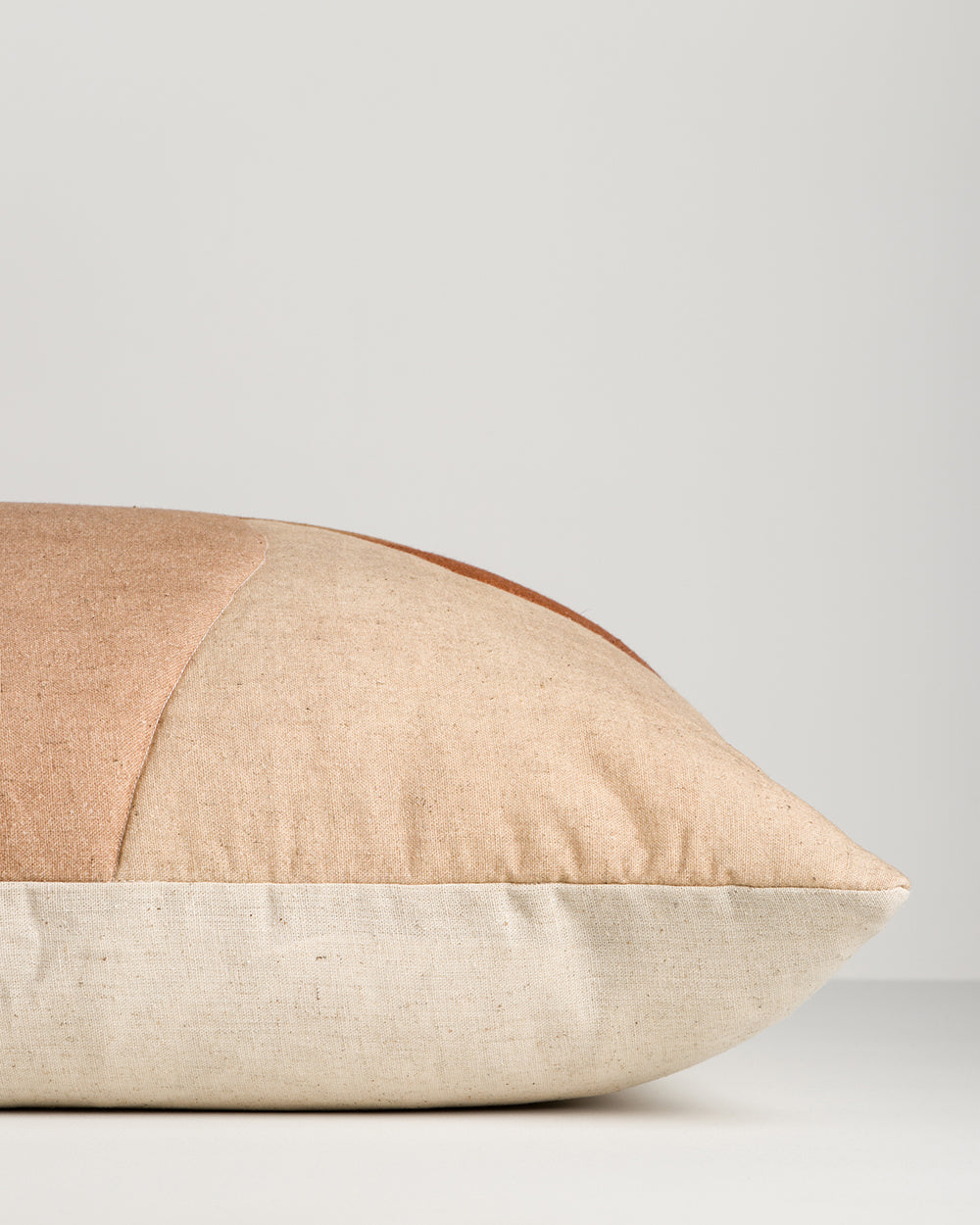 Side view of the Baya Cortile cushion in Multi, showing the solid colour backing behind the printed front.