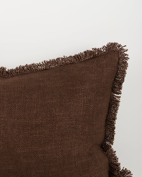 Close detail of the Dover Chocolate lumbar cushion's hand-finished fringe trim and woven texture