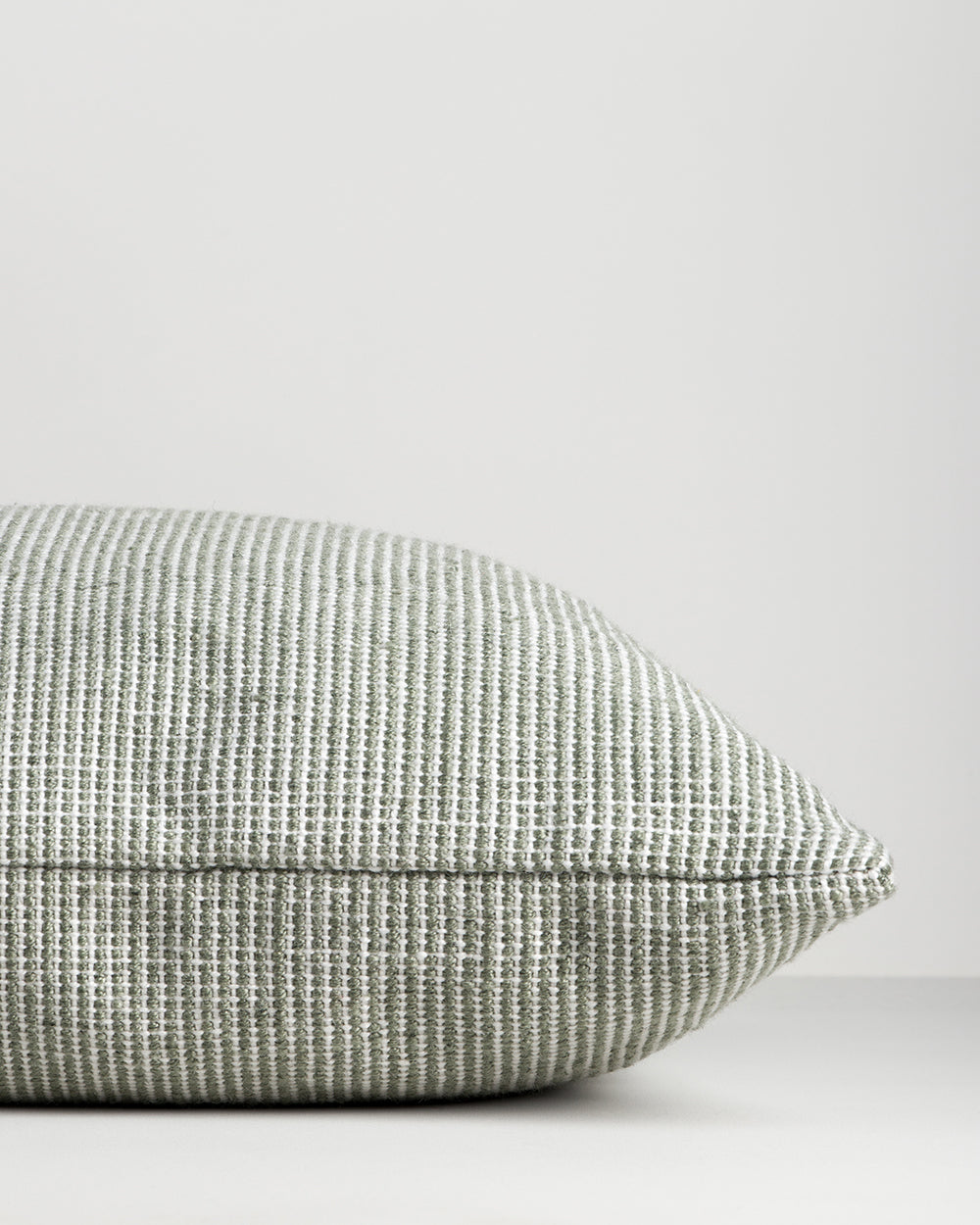 Side profile of the Baya Dune outdoor cushion in Eucalyptus, lying flat, showing the piped seam edge