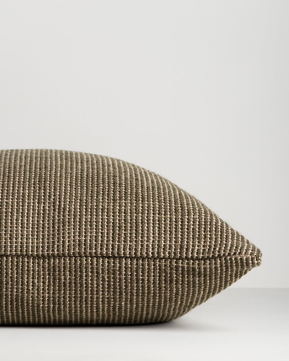 Side profile of the Baya Dune outdoor cushion in Mangrove, lying flat, showing the piped seam edge