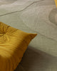 Baya Edgewater NZ wool floor rug in Pistachio, rectangle, close view of the wave pattern beside a mustard lounge chair.