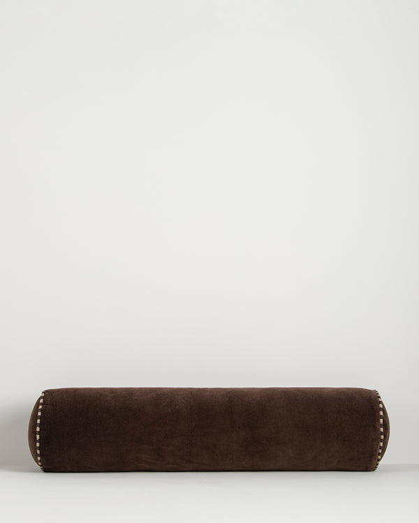 Baya Elliot cotton velvet bolster cushion in Chocolate on a plain background