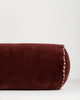 Baya Elliot cotton velvet bolster cushion in Oxblood, close view of the velvet texture and striped piped end