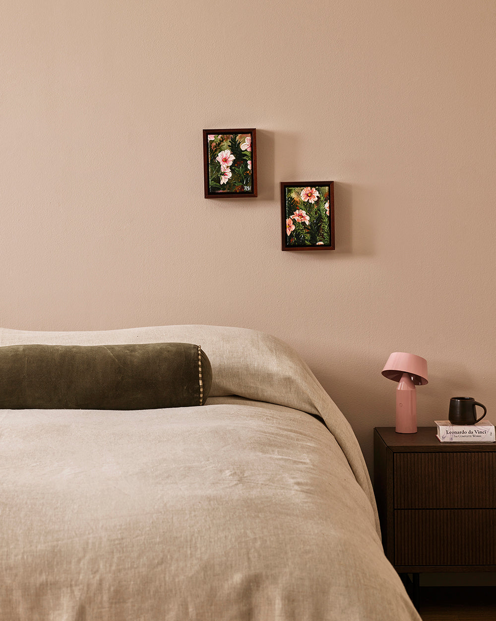 Baya Elliot cotton velvet bolster cushion in Thyme, close view on a bed with natural linen bedding