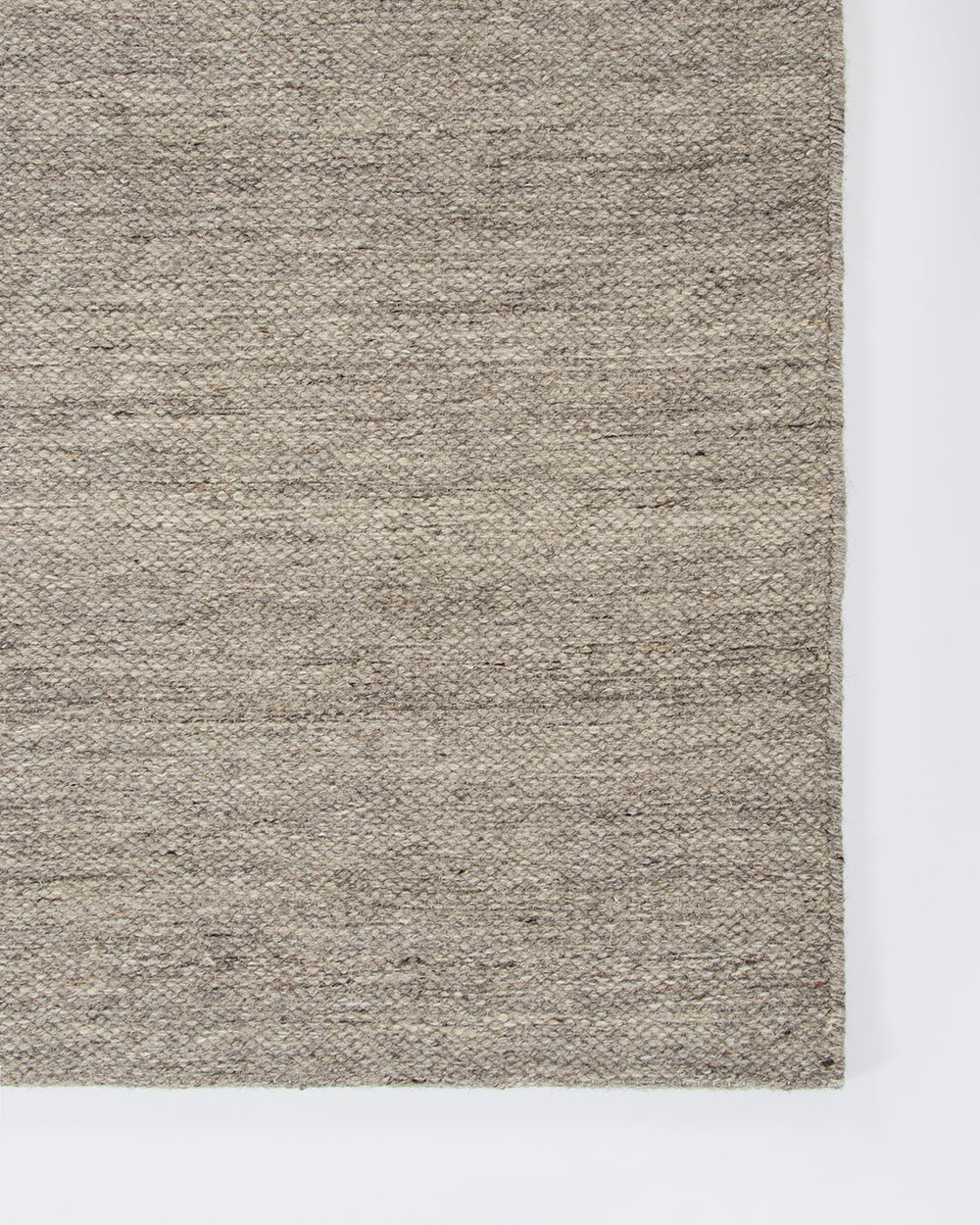 Baya Fairmont NZ Wool Floor Rug in Ash, close view of a folded corner showing the flatweave