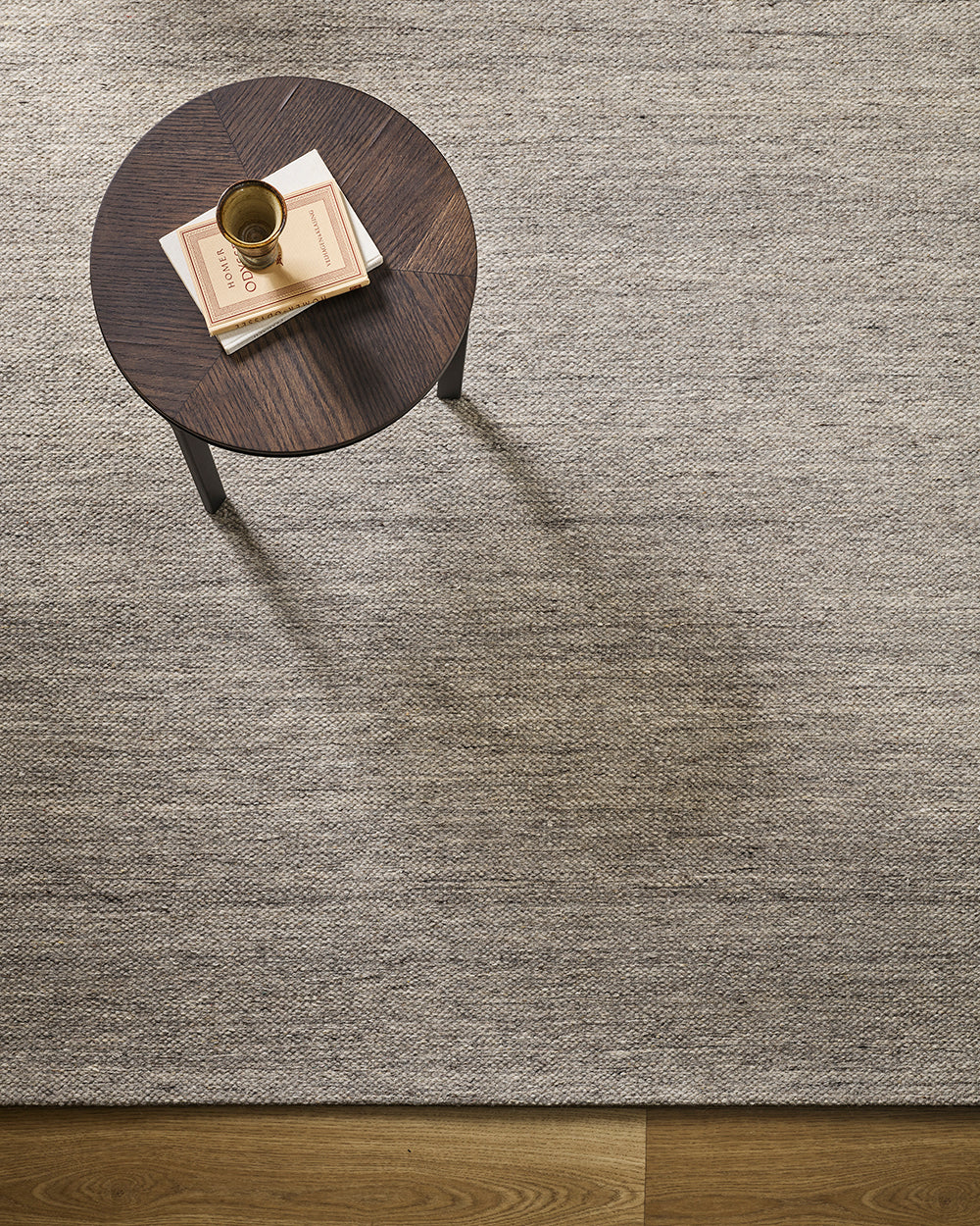 Baya Fairmont NZ Wool Floor Rug in Ash, overhead view beside a round side table with a book and vase