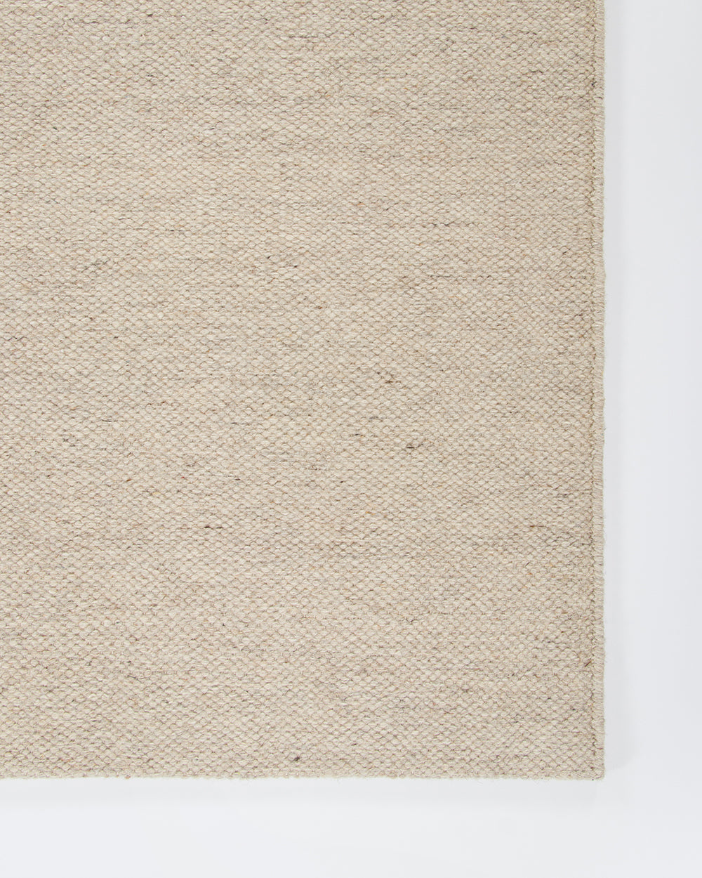 Baya Fairmont NZ Wool Floor Rug in Limestone, close view of a folded corner showing the flatweave