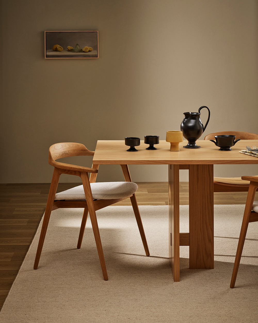 Baya Fairmont NZ Wool Floor Rug in Limestone, under a dining table set with a black jug and ceramics