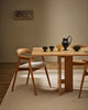 Baya Fairmont NZ Wool Floor Rug in Limestone, under a dining table set with a black jug and ceramics