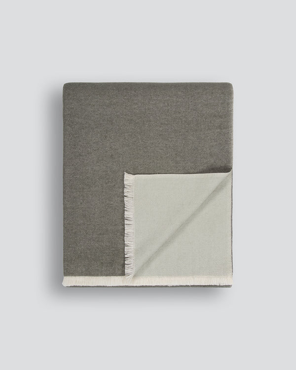 Baya Langford throw in khaki, a dusky green, folded flat to show the fringed edge and pale sage reverse.