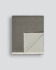 Baya Langford throw in khaki, a dusky green, folded flat to show the fringed edge and pale sage reverse.