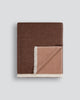 Baya Langford throw in raisin, an earthy red-brown, folded flat to show the fringed edge and beige reverse.