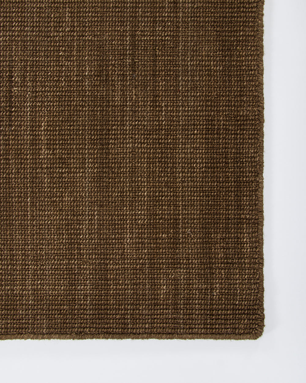 Corner detail of the Baya Linden Floor Rug in Ironbark, showing the flatweave texture and finished fringed edge.