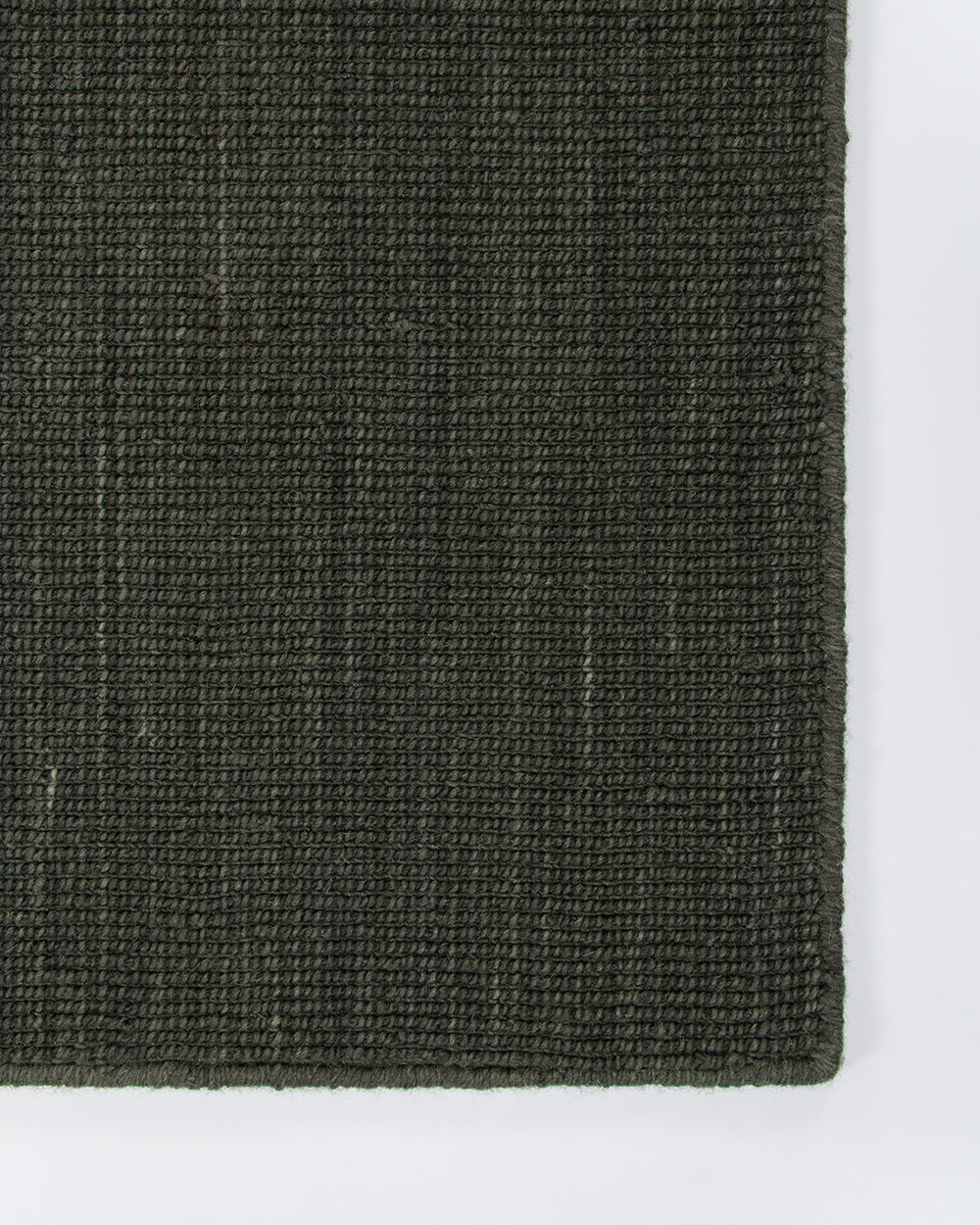 Corner detail of the Baya Linden Floor Rug in Petrol, showing the flatweave texture and finished fringed edge.