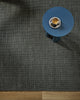 Overhead styling shot of the Baya Linden Floor Rug in Petrol beside a round blue side table with an espresso cup.