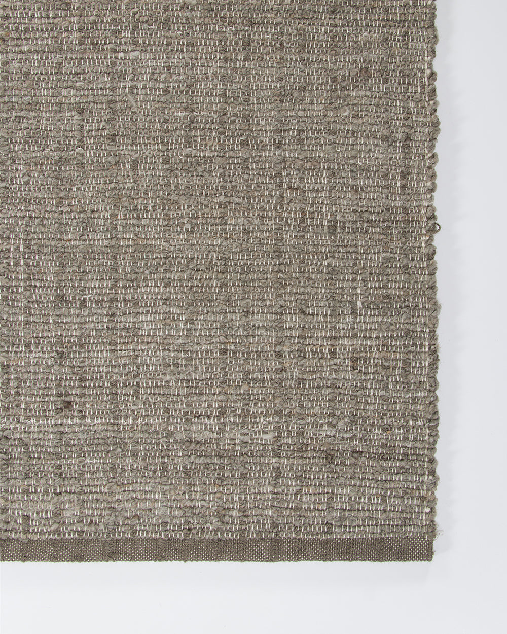 Baya Ormond outdoor rug in Mineral, close view of a corner showing the flat-woven texture and edge.